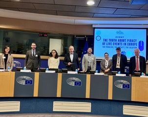 Panel of officials and representatives seated at a table in a European Parliament chamber during a conference on audiovisual piracy.
